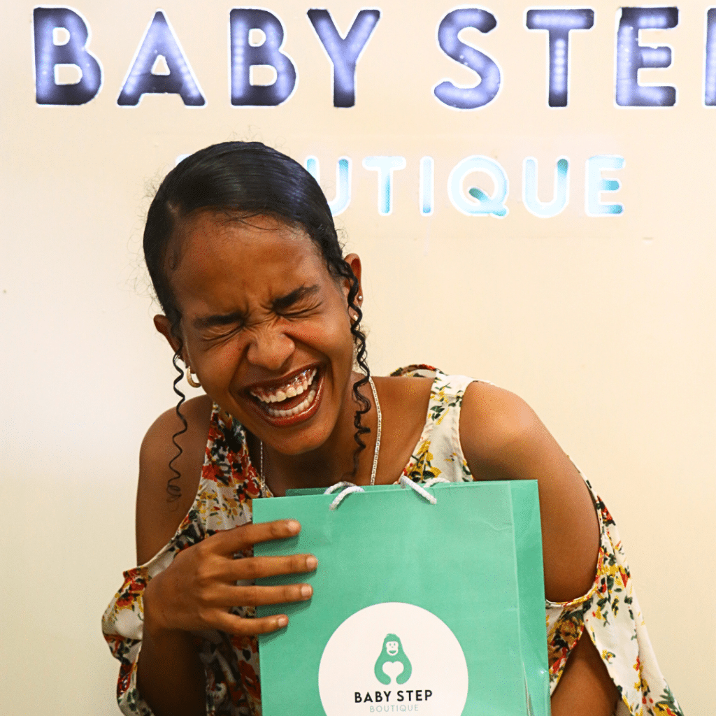 A girl smiling with baby step paper bag